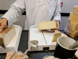 A cheesemonger cuts the cheese.